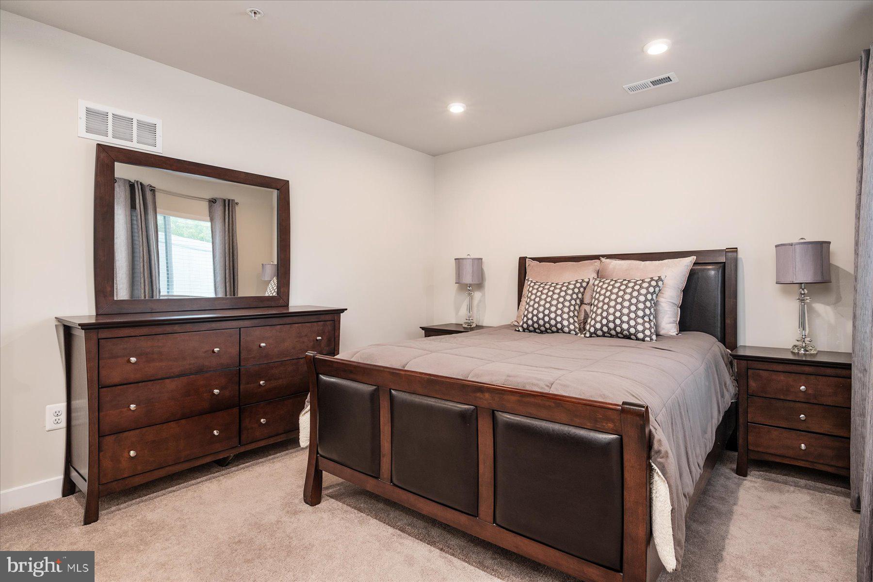 1261 Upper Patuxent Ridge Road Odenton, MD 21113 - Photo 31 of 58 a bedroom with a bed and a mirror on dresser