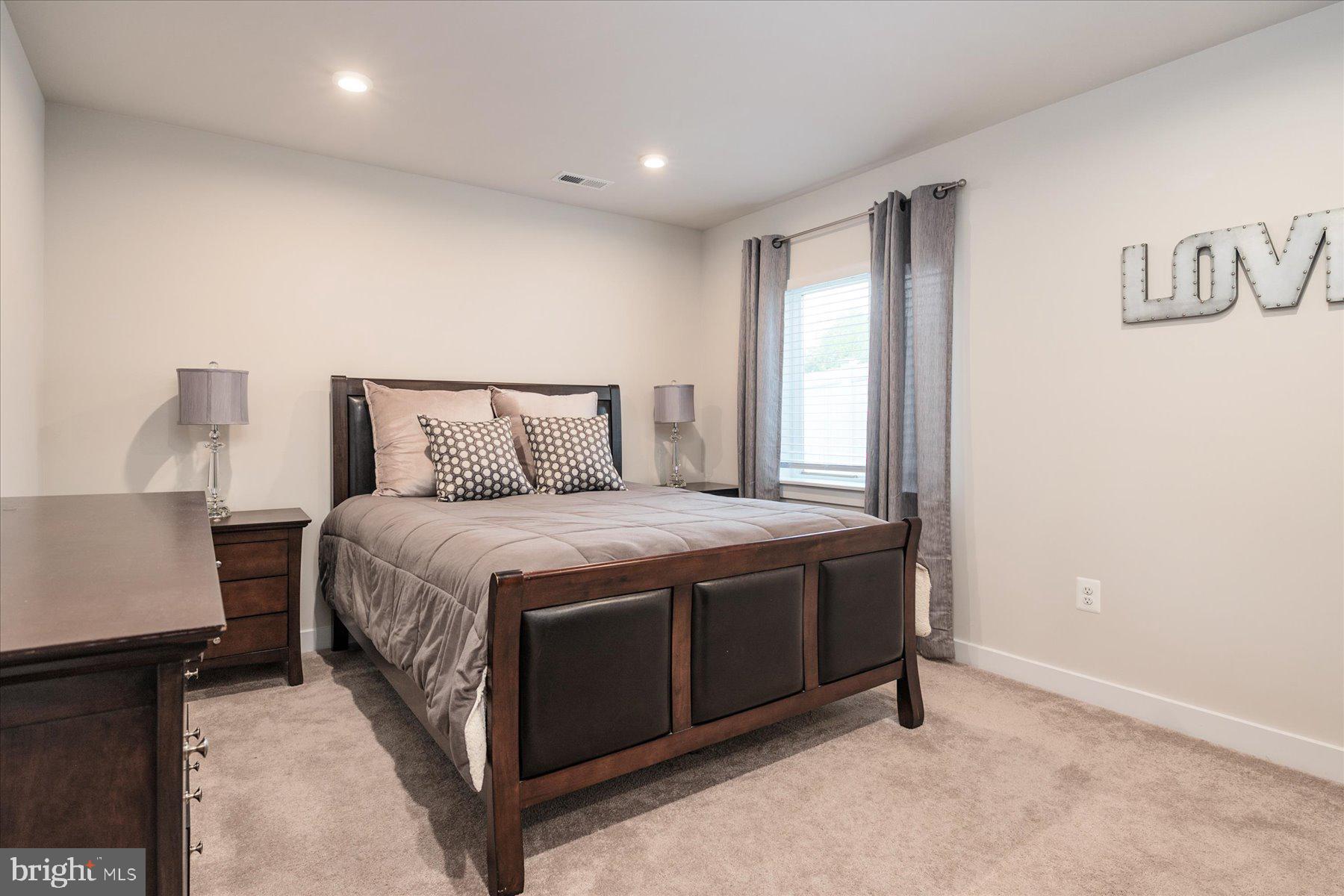 1261 Upper Patuxent Ridge Road Odenton, MD 21113 - Photo 32 of 58 a spacious bedroom with a bed and a lamp with table