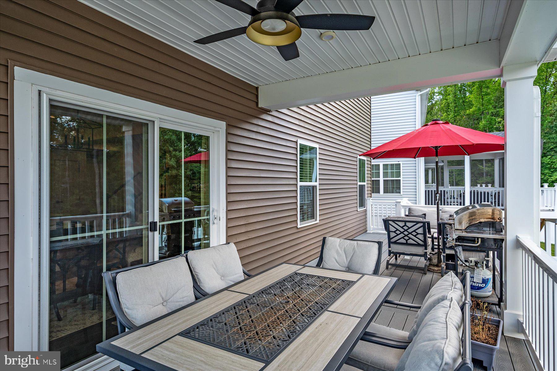 1261 Upper Patuxent Ridge Road Odenton, MD 21113 - Photo 39 of 58 a view of a patio with a dining table and chairs under an umbrella
