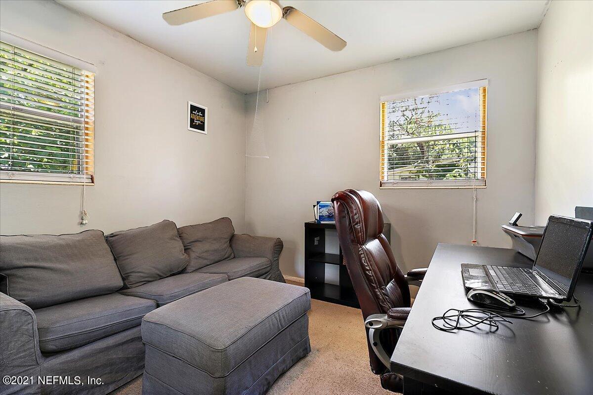 7444 Sandhurst Road South Jacksonville, FL 32277 - Photo 14 of 20 a living room with furniture a chandelier and a window