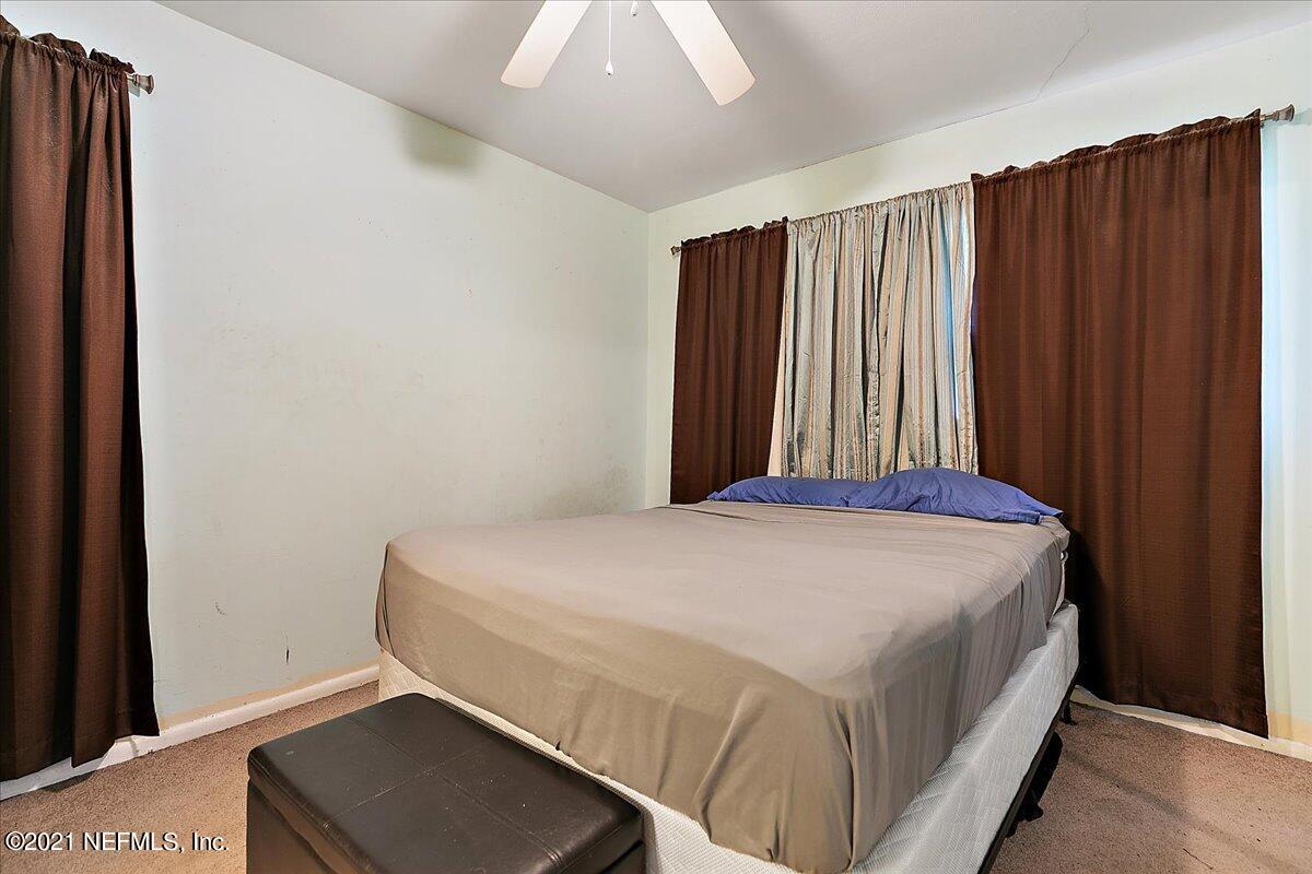 7444 Sandhurst Road South Jacksonville, FL 32277 - Photo 5 of 20 a bed sitting in a bedroom next to a window and closet
