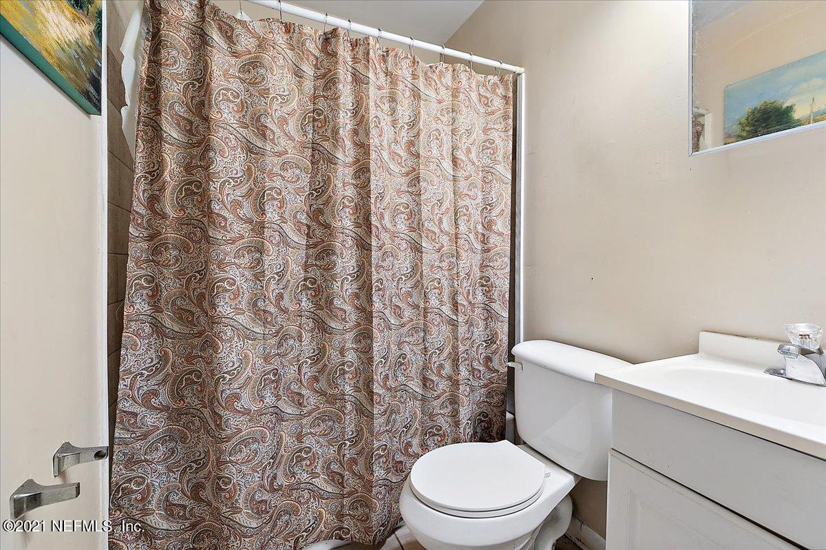 7444 Sandhurst Road South Jacksonville, FL 32277 - Photo 6 of 20 a white toilet sitting next to a white sink and a shower curtain