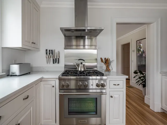 a stove top oven sitting inside of a kitchen