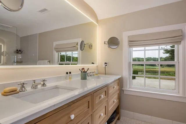 a bathroom with a granite countertop sink mirror and window