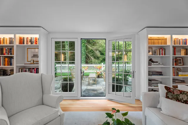 a living room with furniture cabinets and a large window