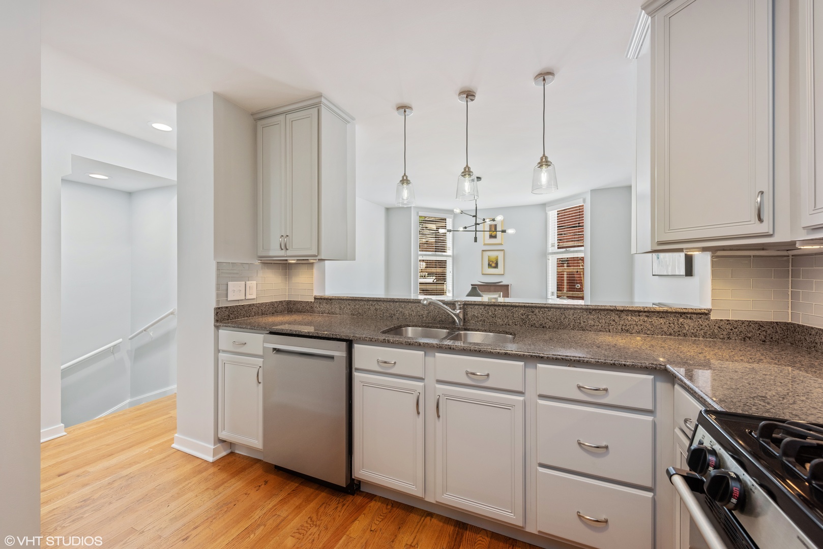 2024 North Racine Avenue, Unit M Chicago, IL 60614 - Photo 7 of 22 a kitchen with granite countertop white cabinets and a wooden floor
