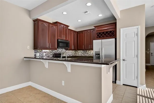 a kitchen with stainless steel appliances granite countertop a refrigerator and a sink