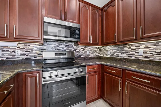 a kitchen with stainless steel appliances granite countertop a sink stove and microwave