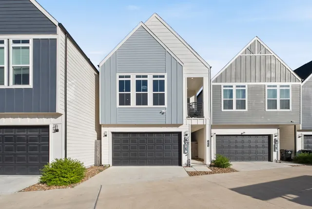 a front view of a house with yard and parking