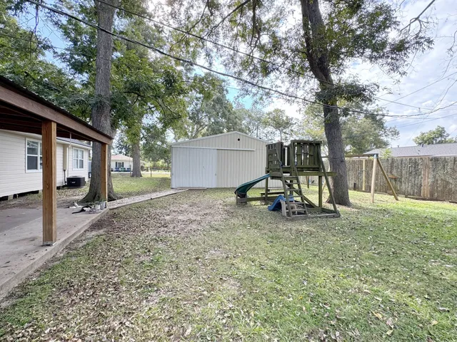 a view of a house with backyard and a tree