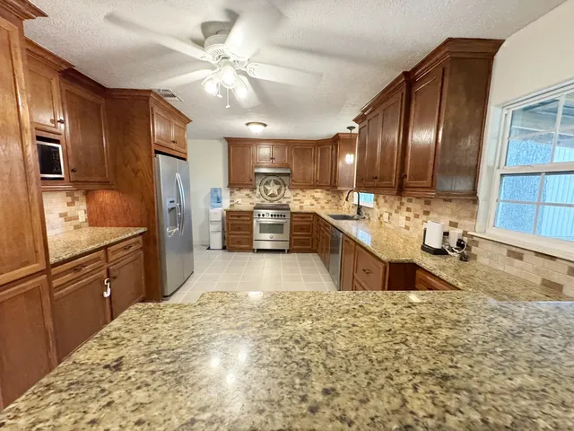 a kitchen with a stove a refrigerator and a sink