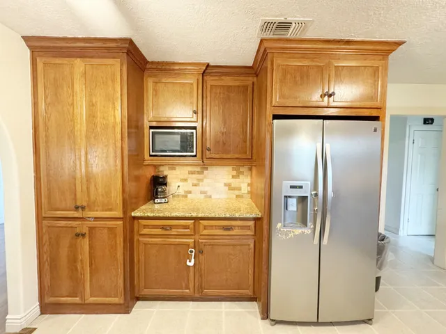 a kitchen with stainless steel appliances granite countertop a refrigerator and a stove
