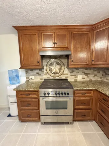 a stove top oven sitting inside of a kitchen