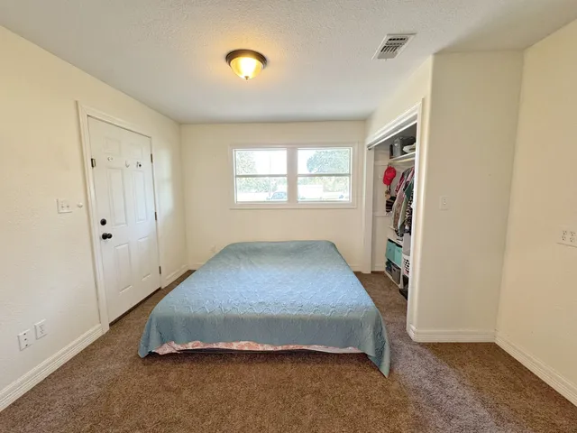 a spacious bedroom with a bed and a window
