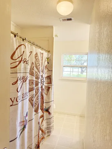 a bathroom with a shower curtain and a window