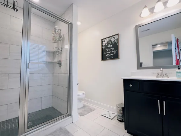 a bathroom with a sink a toilet a shower and a mirror