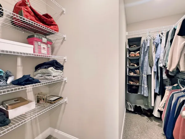 a view of walk in closet with clothes and shoes