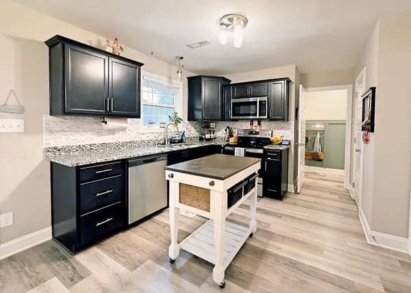 a kitchen with a stove refrigerator and microwave