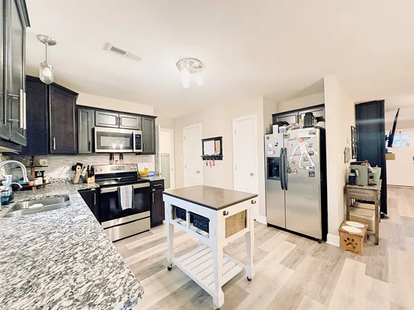 a kitchen with stainless steel appliances granite countertop a refrigerator stove and oven