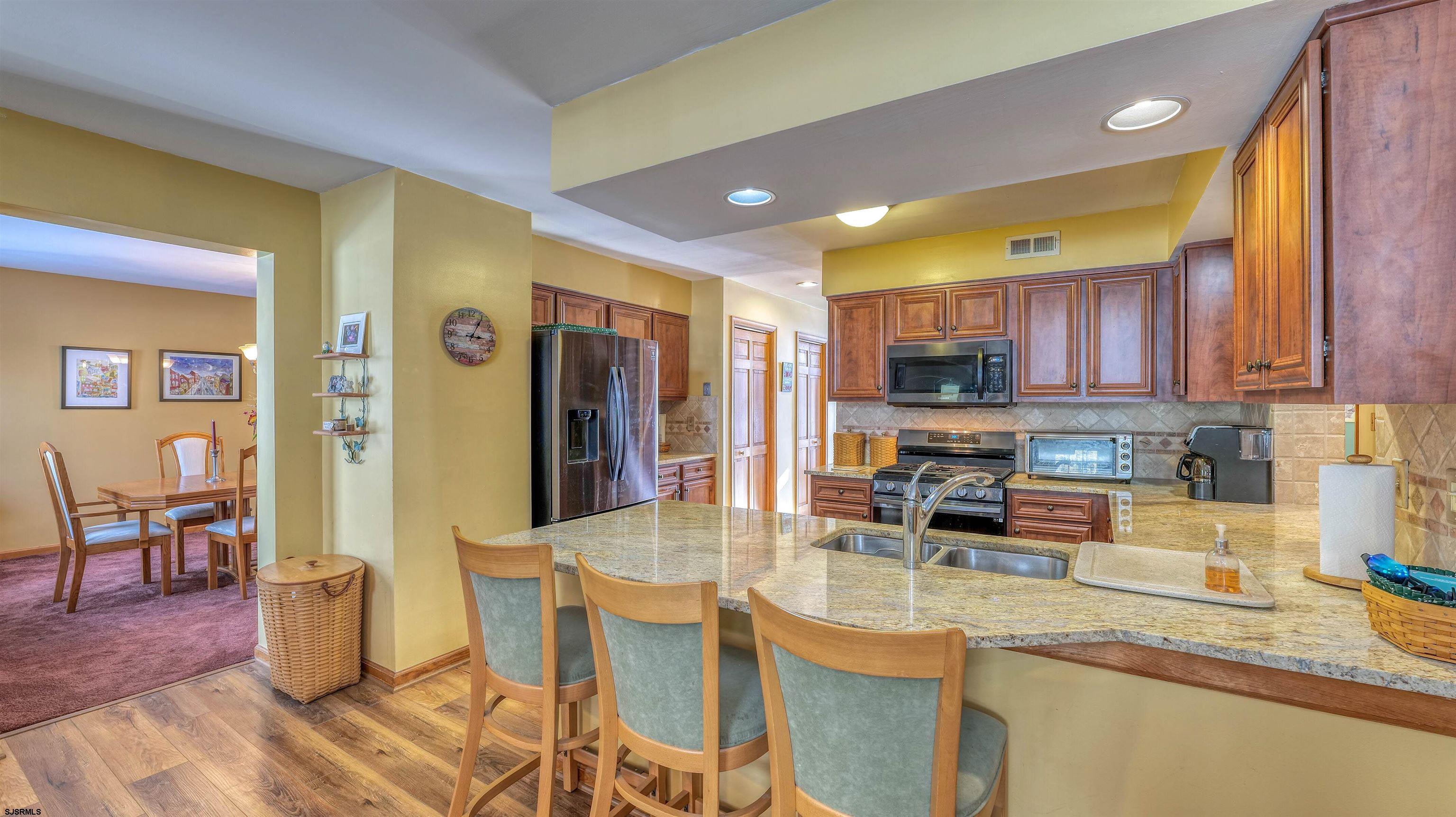 627 East Seaview Ridge Drive Galloway Township, NJ 08205 - Photo 19 of 50 a kitchen with stainless steel appliances granite countertop a sink a stove a refrigerator cabinets and dining table