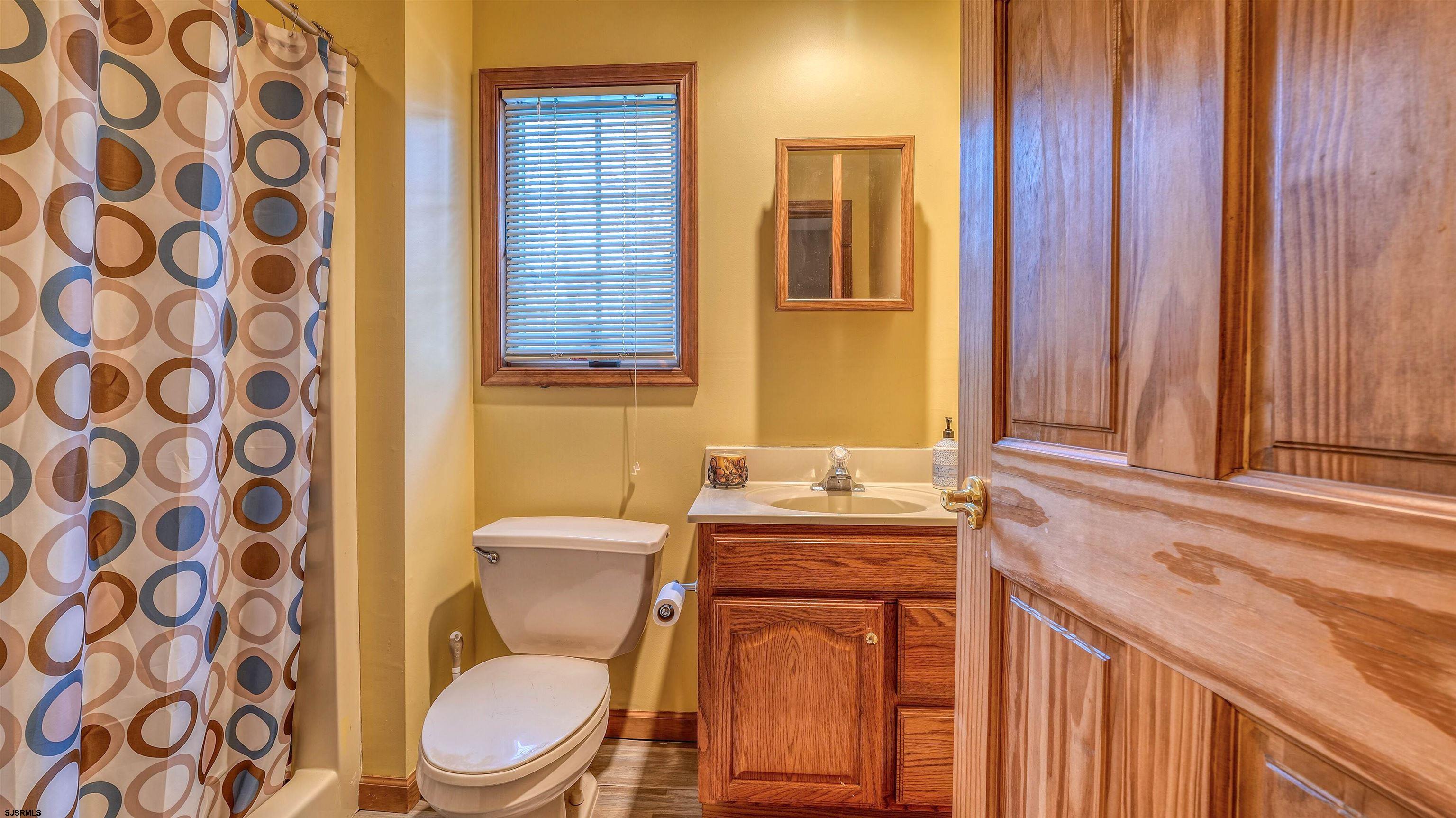 627 East Seaview Ridge Drive Galloway Township, NJ 08205 - Photo 39 of 50 a bathroom with a toilet a sink and a shower curtain