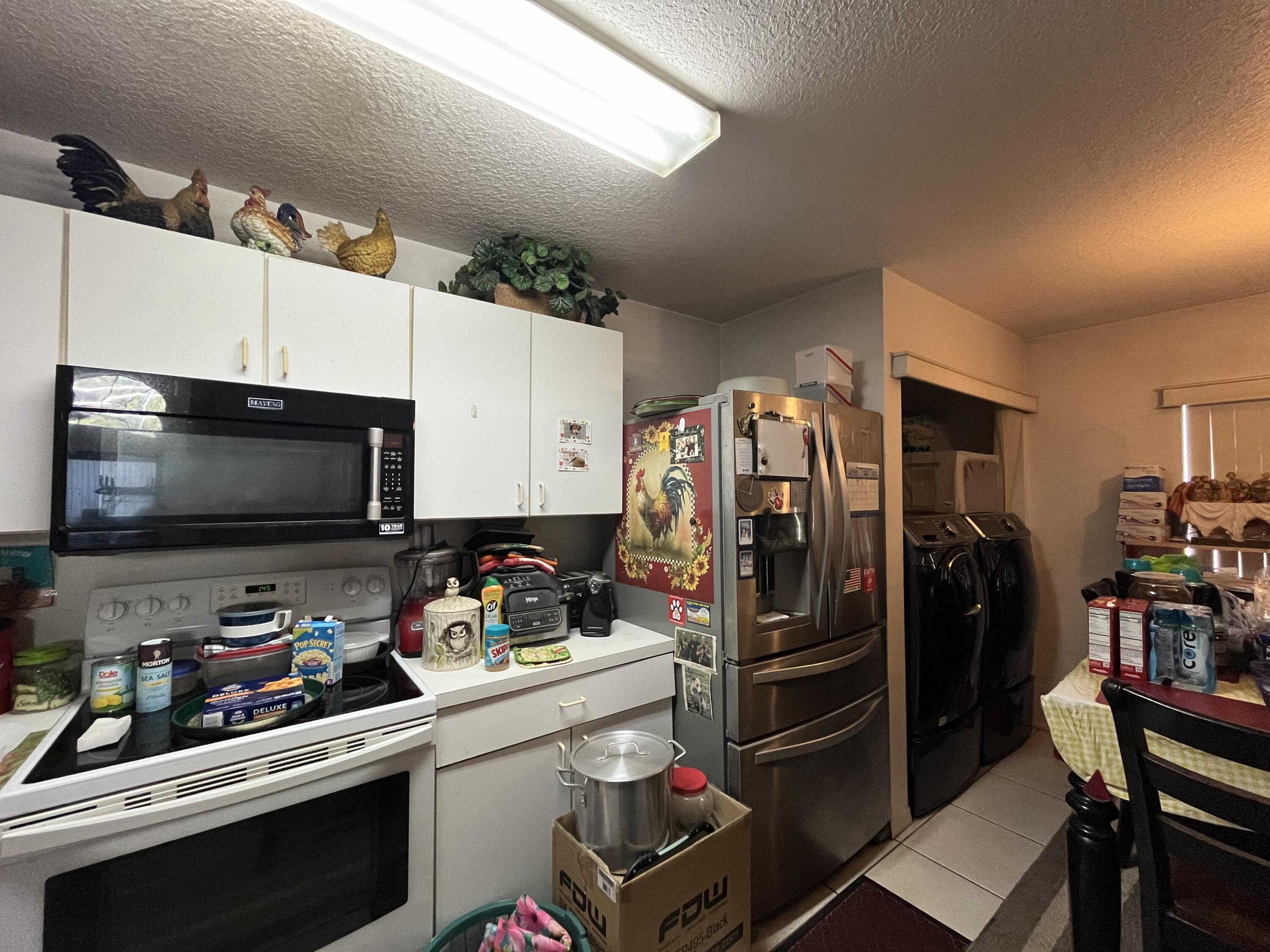 4919 Erin Lane Melbourne, FL 32940 - Photo 3 of 13 a kitchen with a refrigerator and a stove top oven