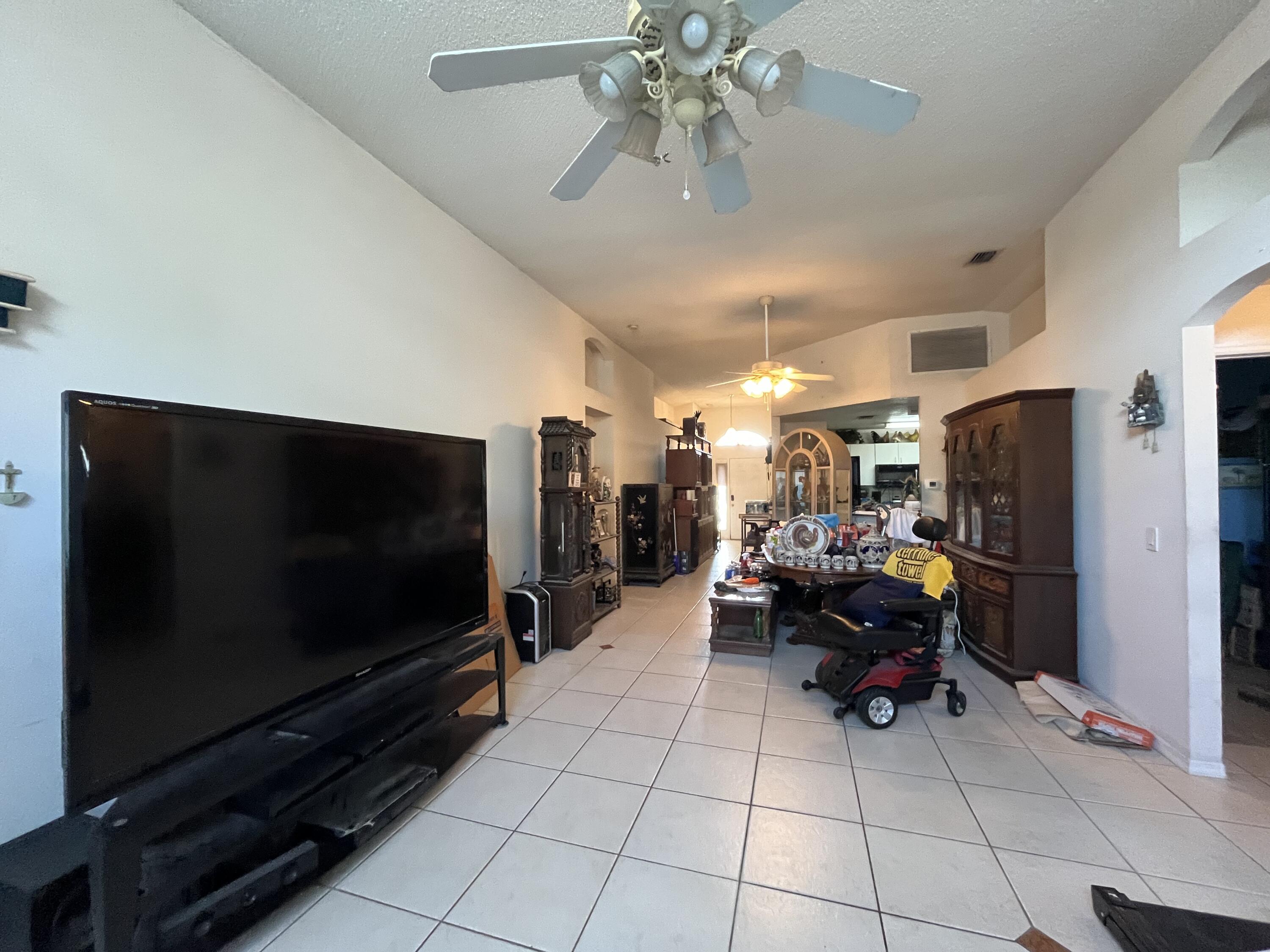 4919 Erin Lane Melbourne, FL 32940 - Photo 5 of 13 a living room with furniture and a flat screen tv