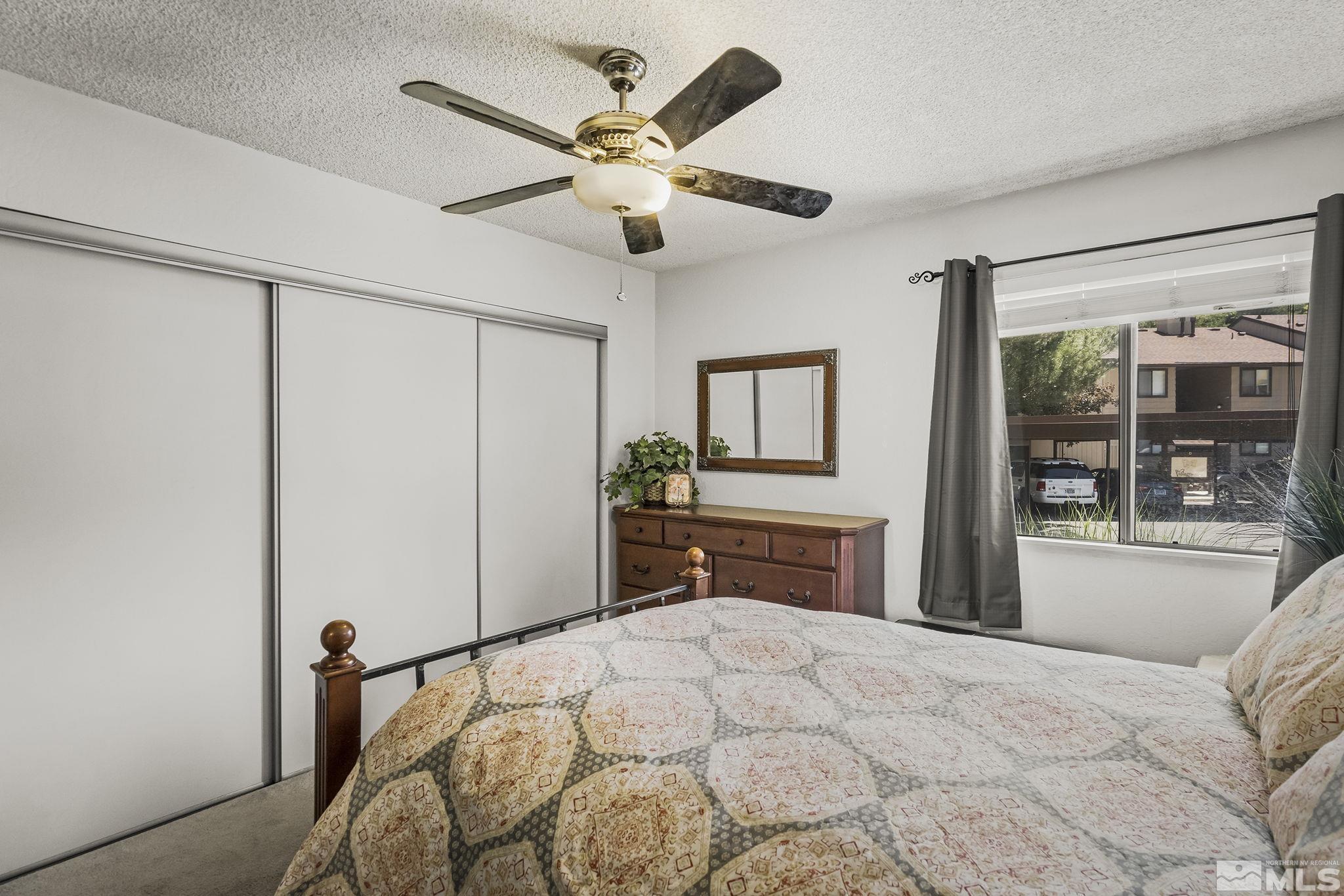 4640 Rio Poco Road Reno, NV 89502 - Photo 12 of 15 a bedroom with a large bed and a chandelier