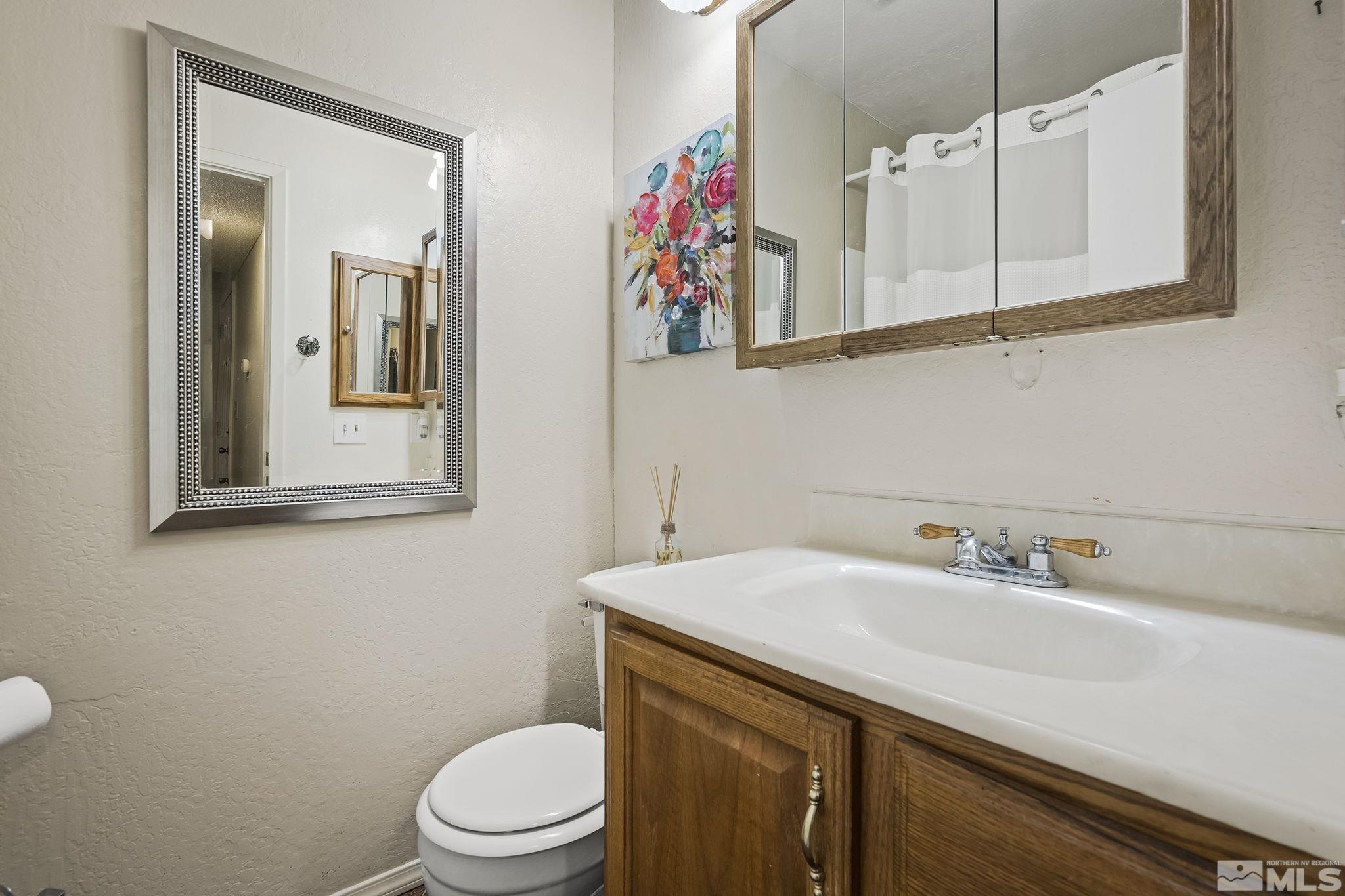 4640 Rio Poco Road Reno, NV 89502 - Photo 13 of 15 a bathroom with a sink a toilet and mirror