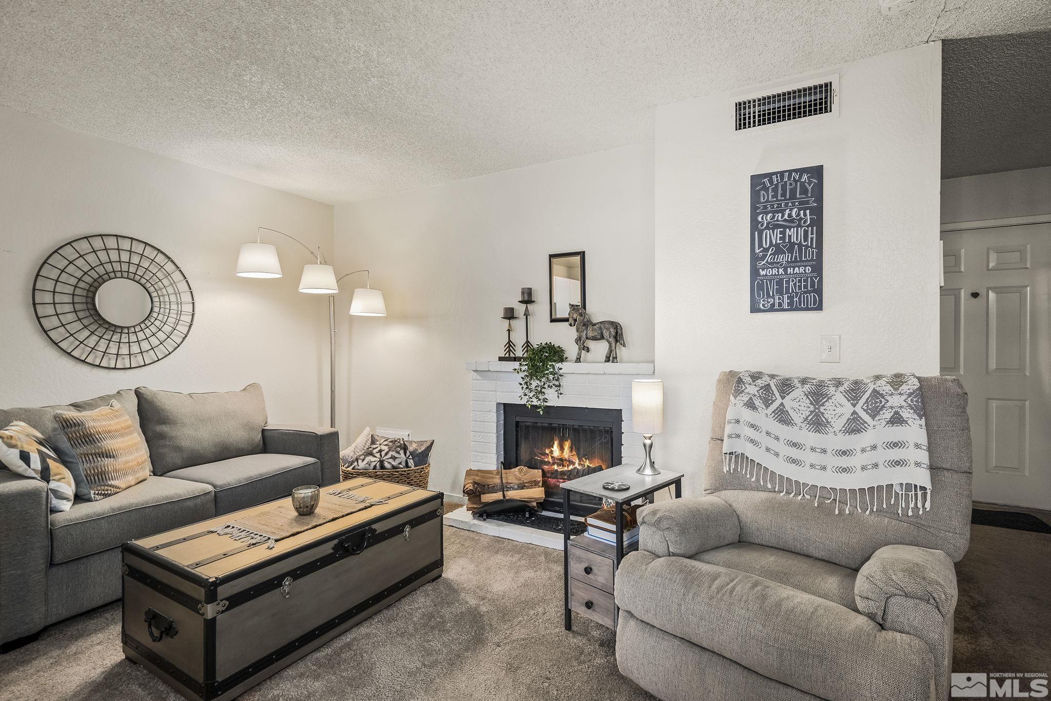 4640 Rio Poco Road Reno, NV 89502 - Photo 5 of 15 a living room with furniture a fireplace and a rug