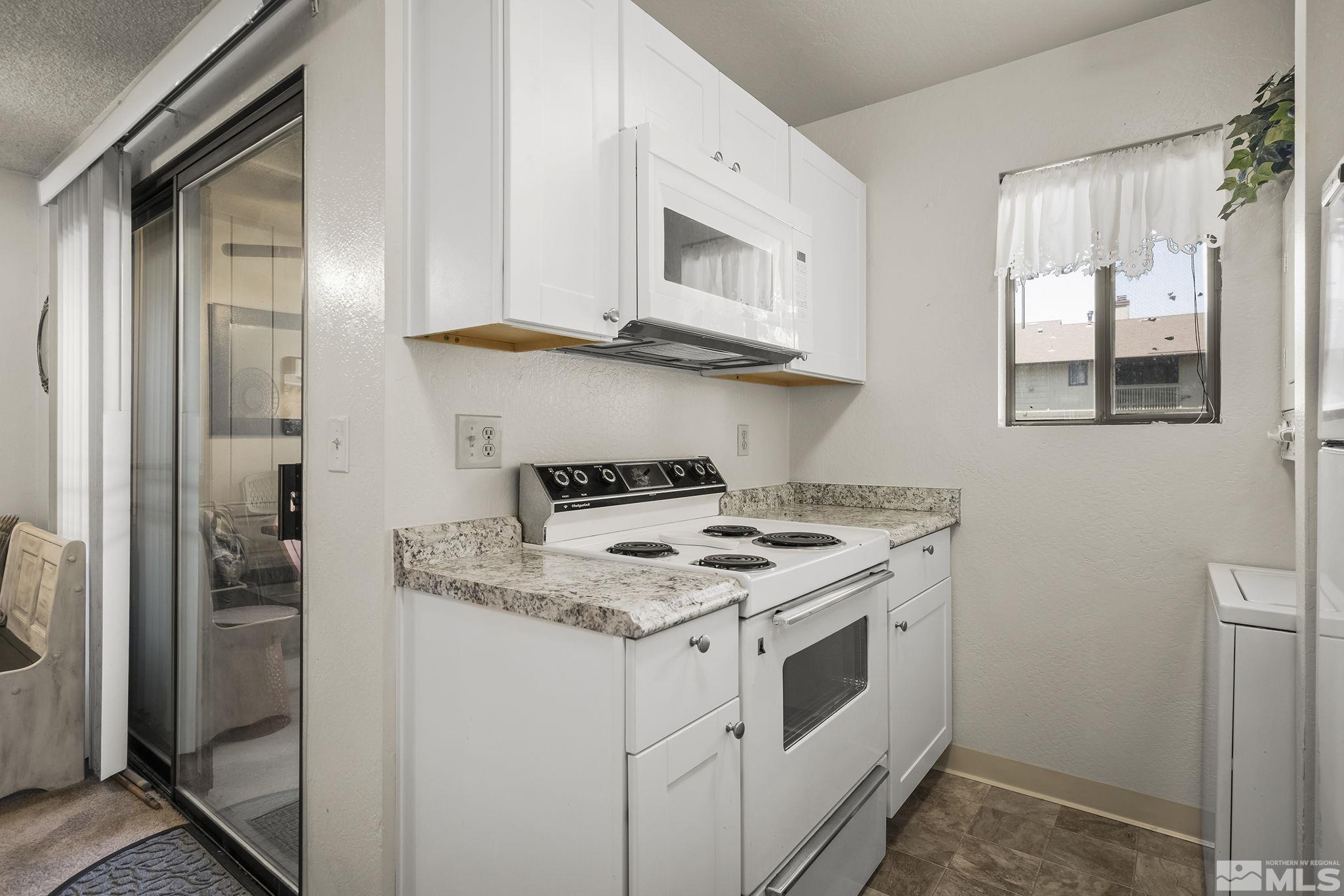 4640 Rio Poco Road Reno, NV 89502 - Photo 9 of 15 a kitchen with stainless steel appliances granite countertop a stove a sink and a refrigerator