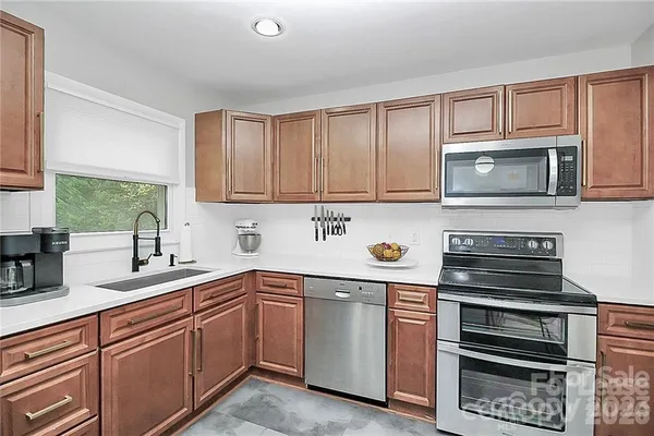 a kitchen with stainless steel appliances a stove sink microwave and cabinets