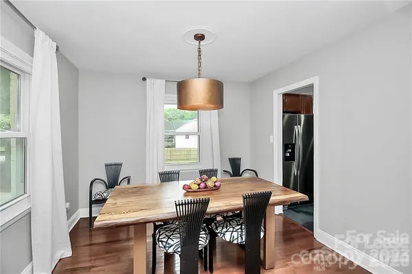 a view of a a dining room with furniture window and wooden floor