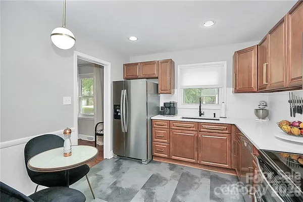 a kitchen with a sink a refrigerator and cabinets