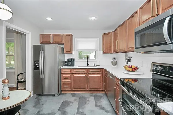 a kitchen with stainless steel appliances a refrigerator a stove a sink and a microwave