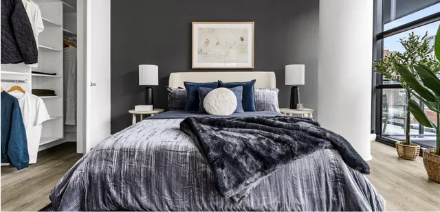 a bed sitting in a bedroom next to a tv with a flat screen tv