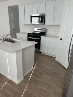 a kitchen with a sink a stove and cabinets