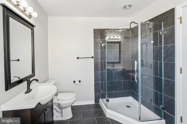 a bathroom with a shower a sink and toilet
