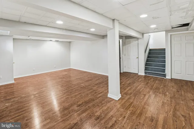 an empty room with wooden floor and entryway