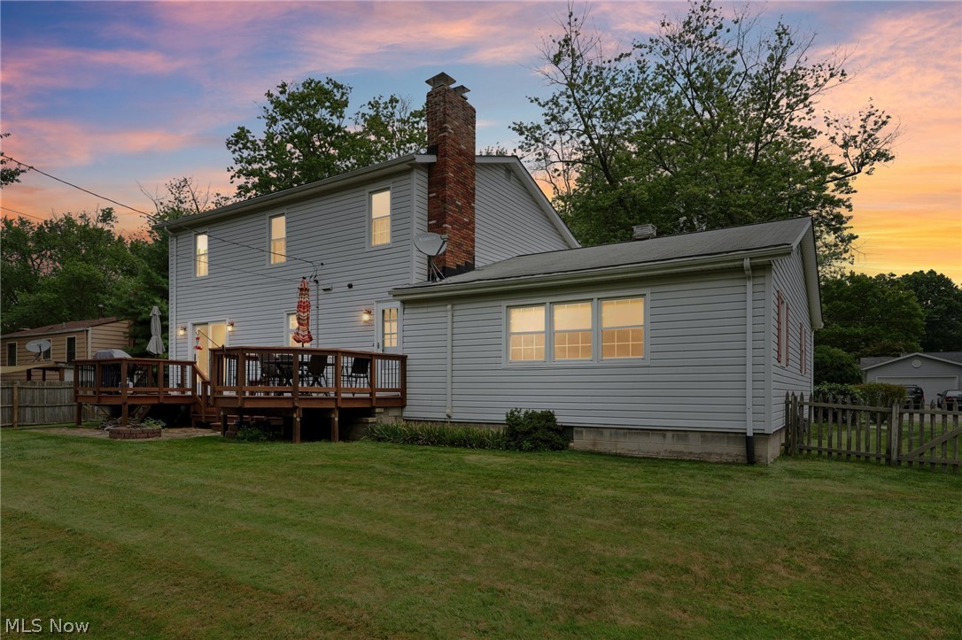 1762 Stonehaven Road Madison, OH 44057 - Photo 30 of 36 Back house at dusk with a wooden deck and a yard