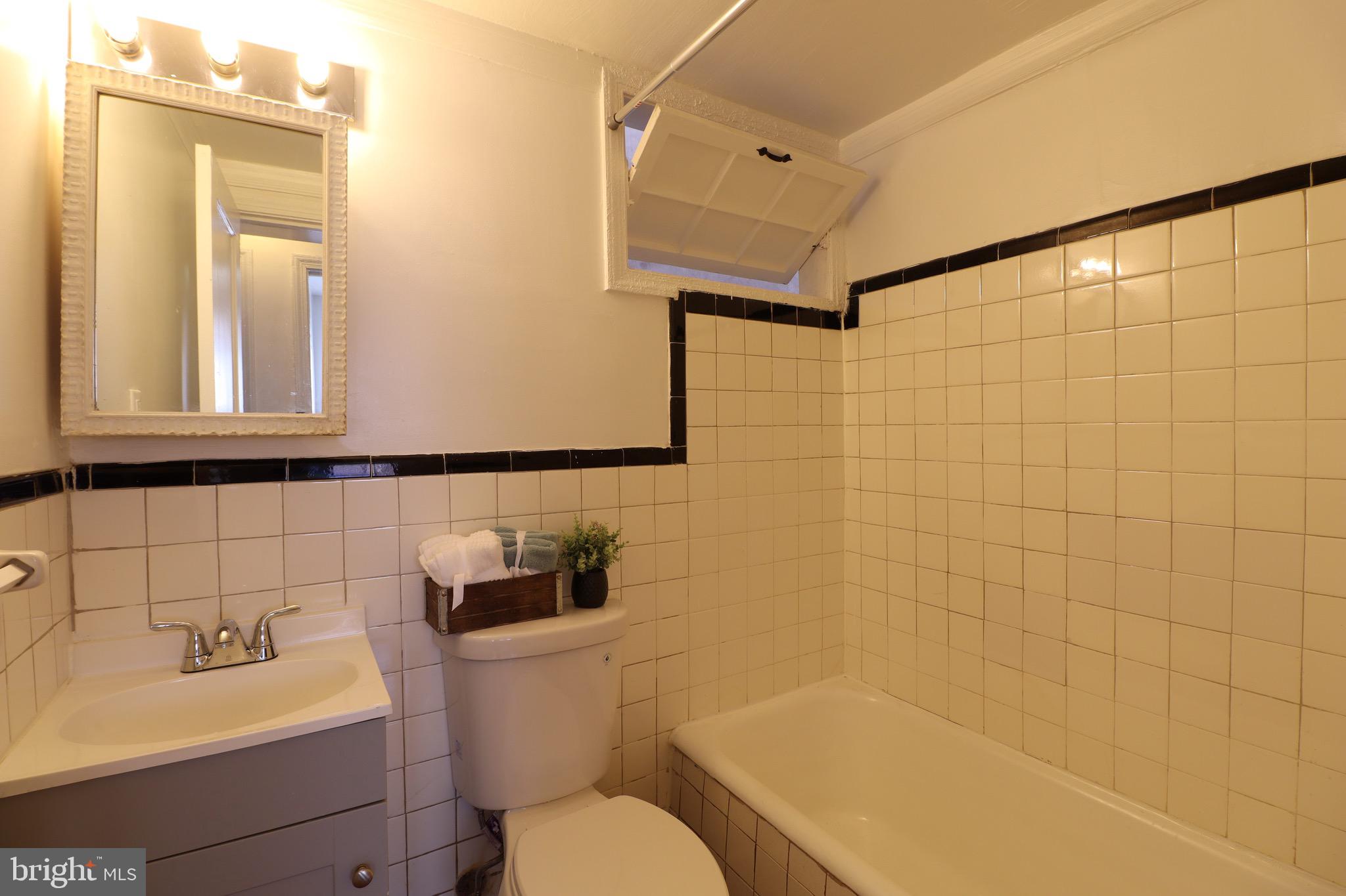 407 Lebaum Street Southeast, Unit 1 Washington, DC 20032 - Photo 11 of 11 a bathroom with a sink mirror toilet and bathtub