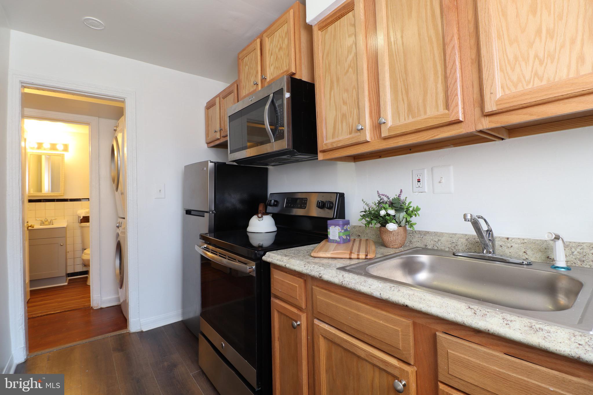 407 Lebaum Street Southeast, Unit 1 Washington, DC 20032 - Photo 3 of 11 a kitchen with stainless steel appliances granite countertop a sink a stove and cabinets