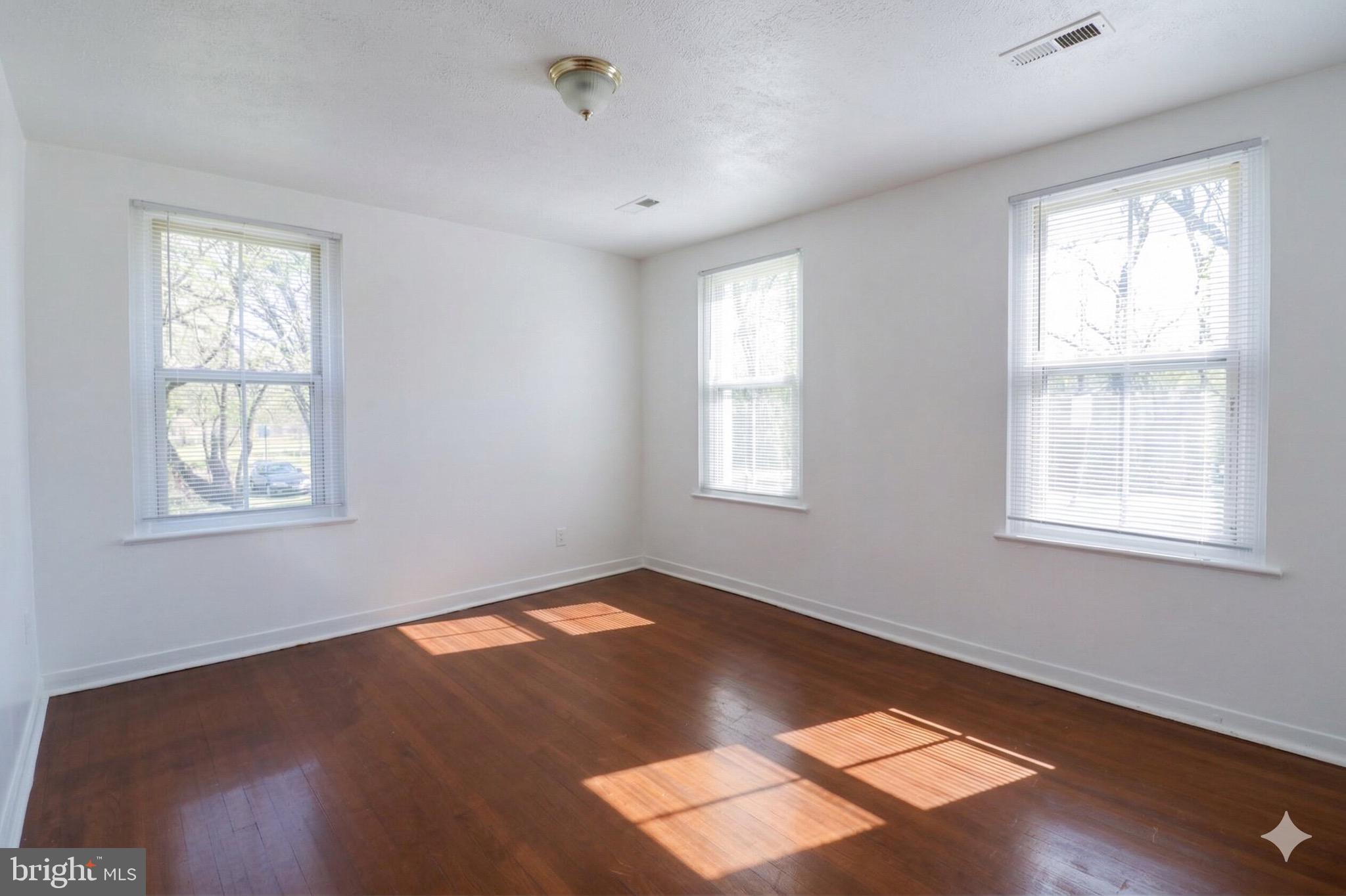 407 Lebaum Street Southeast, Unit 1 Washington, DC 20032 - Photo 4 of 11 a view of an empty room with wooden floor and a window