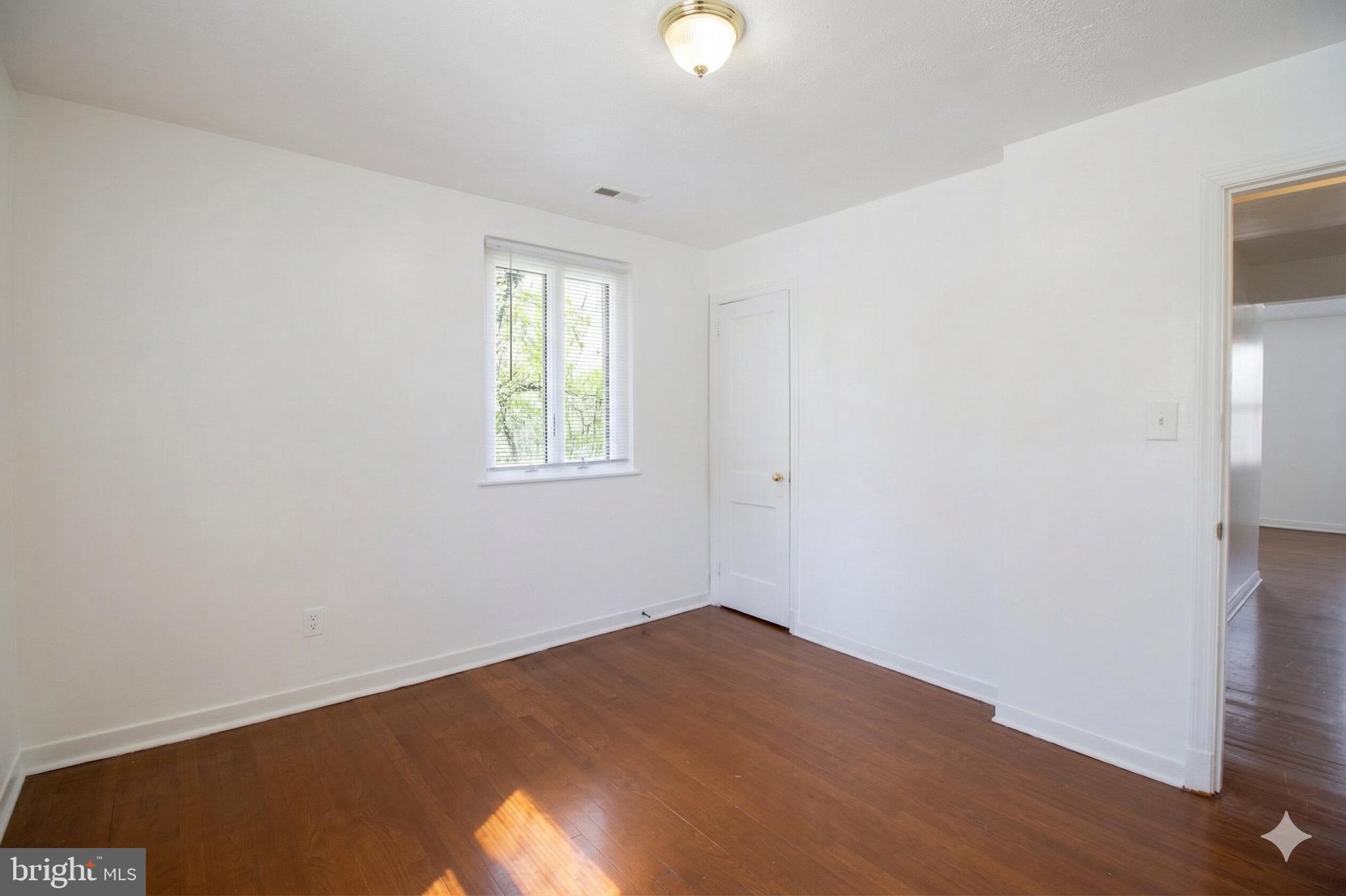 407 Lebaum Street Southeast, Unit 1 Washington, DC 20032 - Photo 6 of 11 an empty room with wooden floor and windows