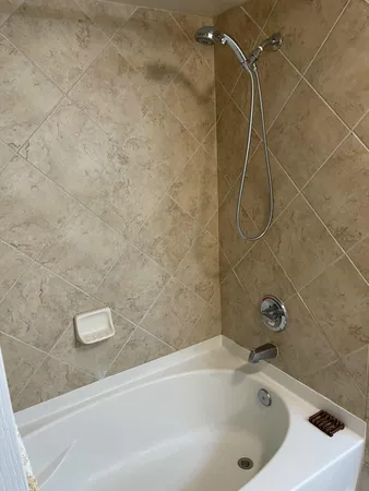 a bathroom with a white bath tub and a shower