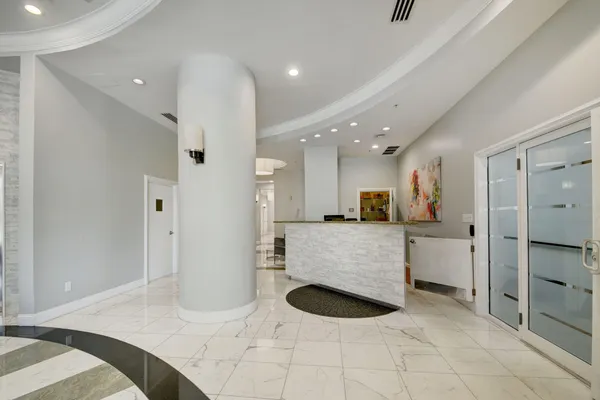 a living room with furniture and a refrigerator