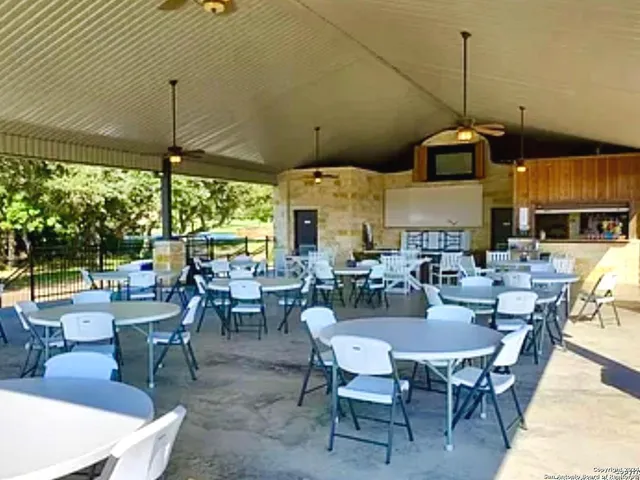 a view of a chairs and table on wooden deck with lake view
