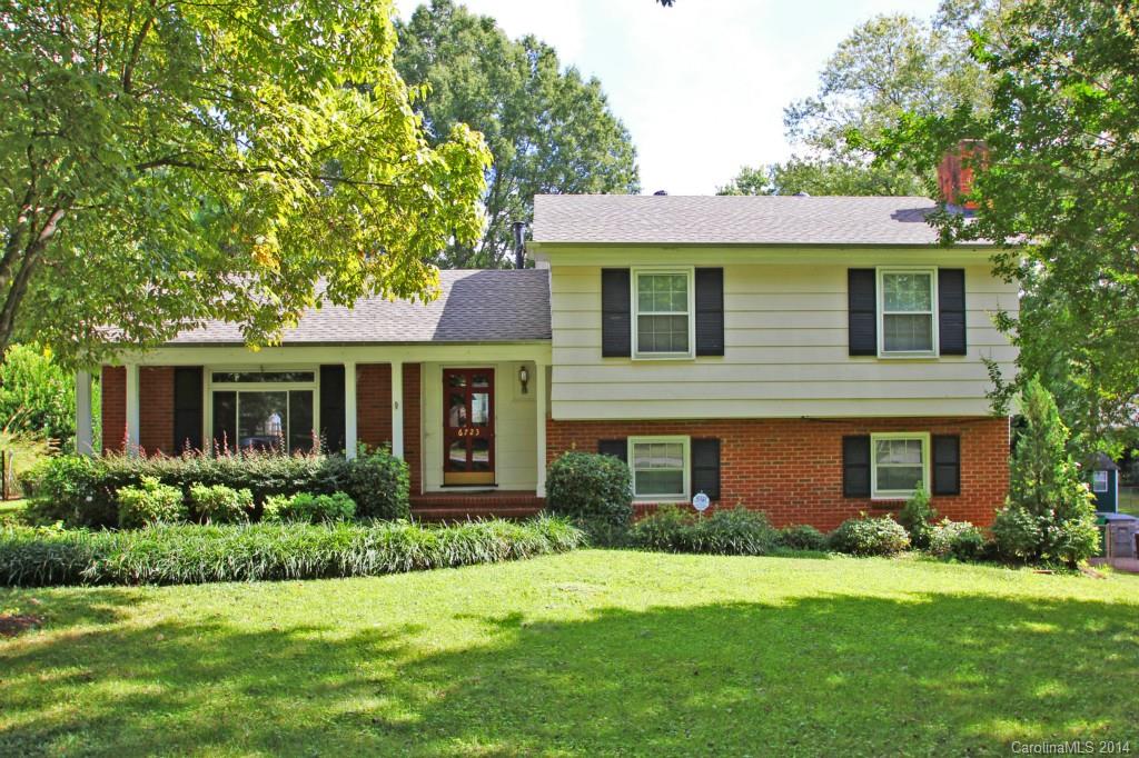 a front view of a house with a yard and trees