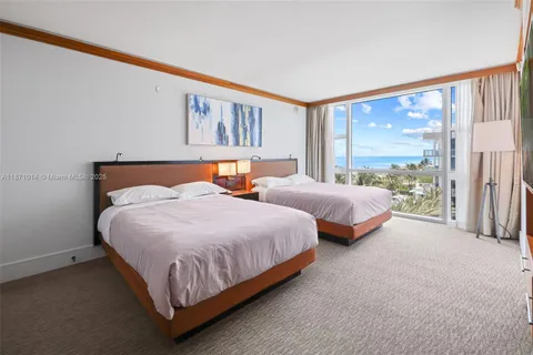 a bedroom with two beds and large window