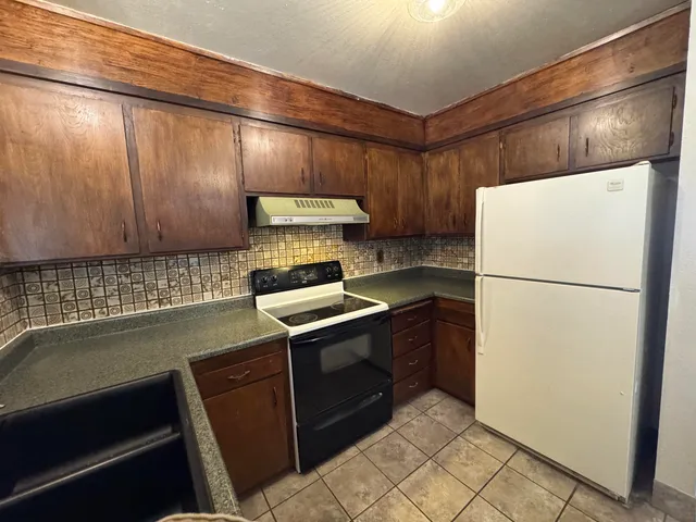 a kitchen with stainless steel appliances granite countertop a sink and a stove